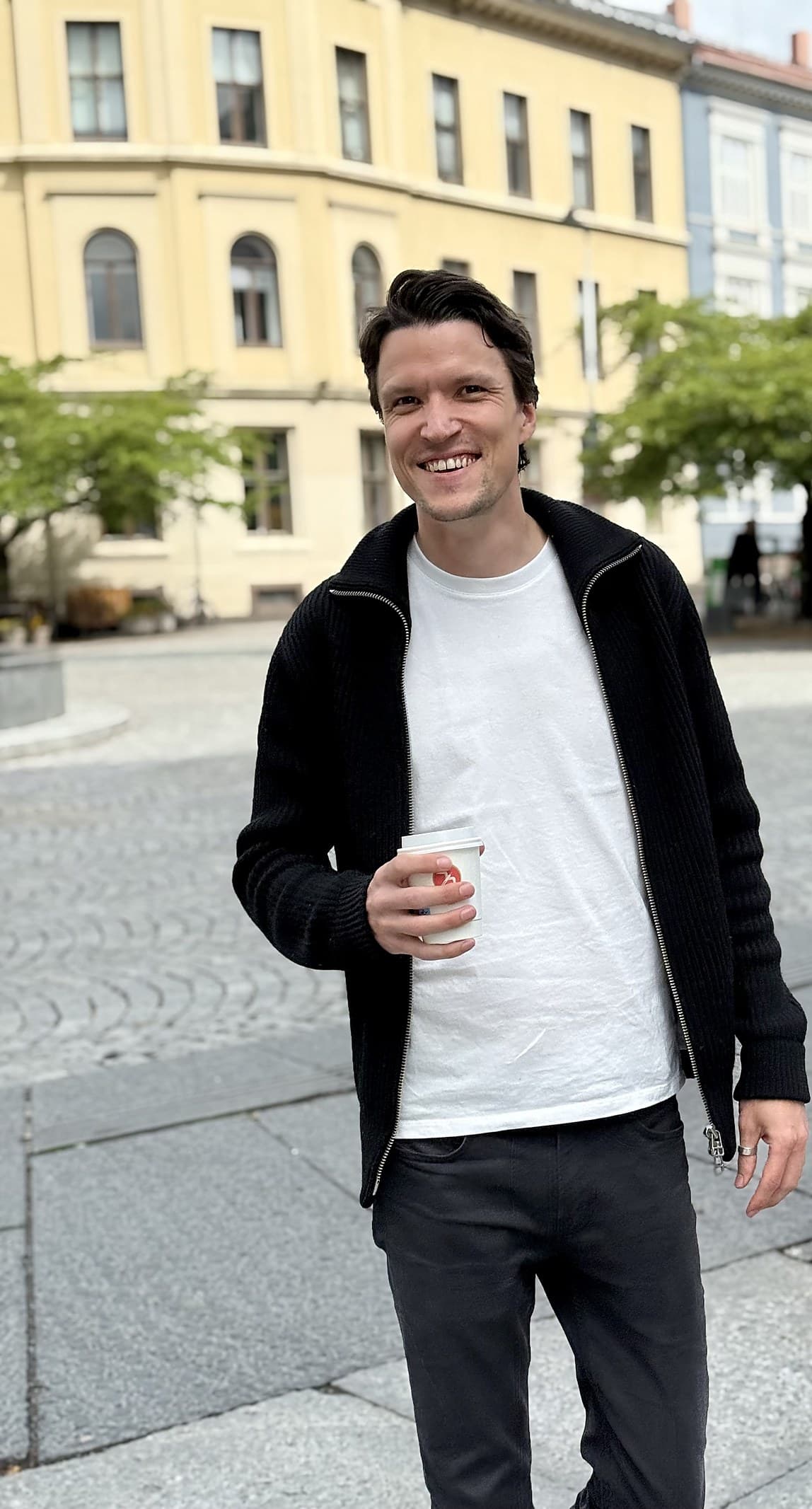 Ole Jørgen Grønli med en kaffekopp på et torg i Oslo